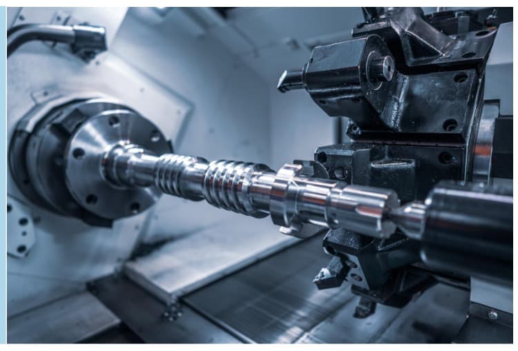 CNC torna tezgahında işlenen metal mil